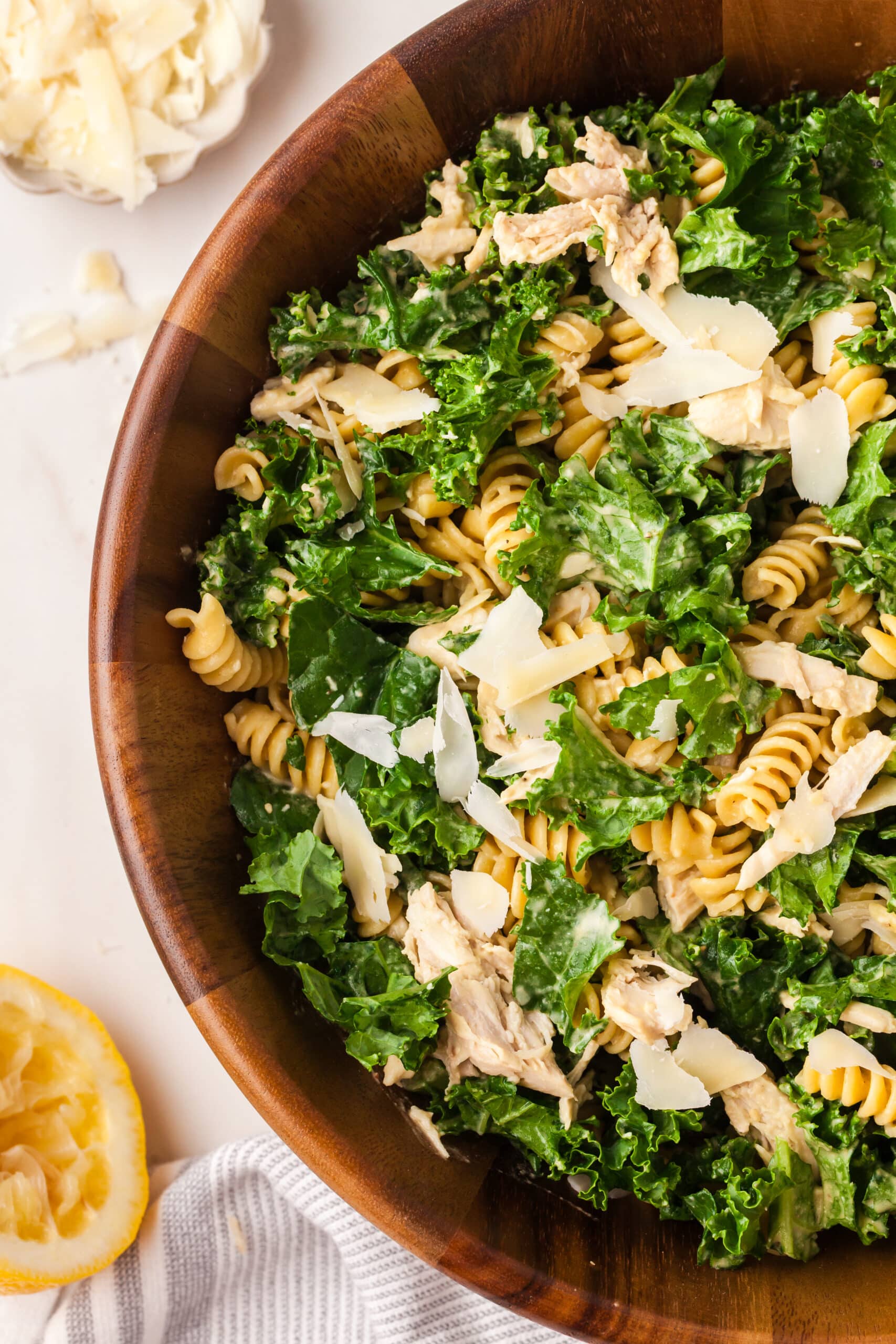 kale pasta caesar salad in wood bowl.