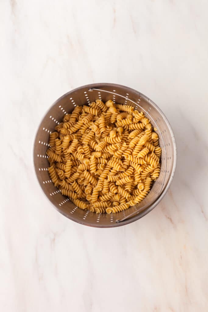 process shots on how to make a kale pasta caesar salad.