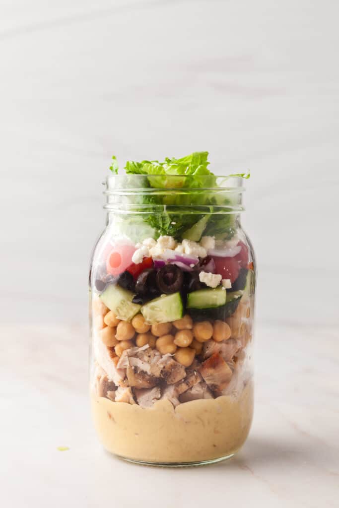process shots of a pcos friendly mason jar salad being made.