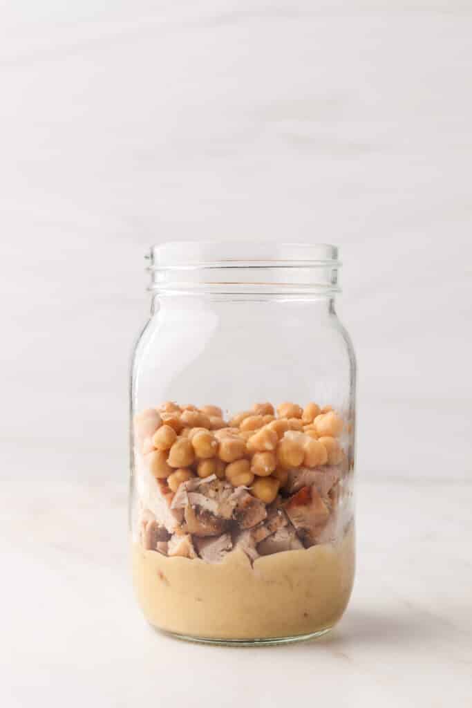 process shots of a pcos friendly mason jar salad being made.