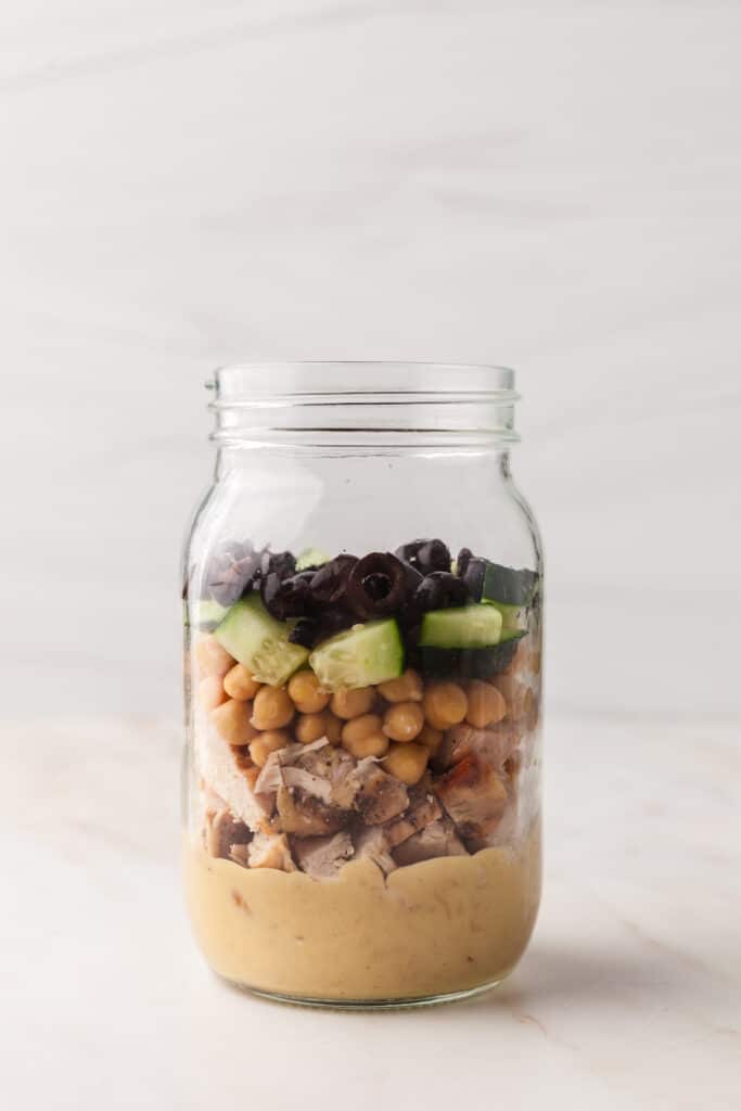 process shots of a pcos friendly mason jar salad being made.